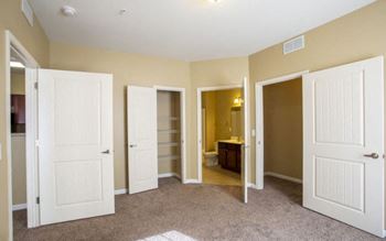 A room with four doors and a carpet on the floor. at The Parker at Cone Apartments, Greenville